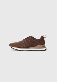 Brown suede sneaker featuring a textured finish, round laces, and a contrasting white midsole with a black rubber outsole.