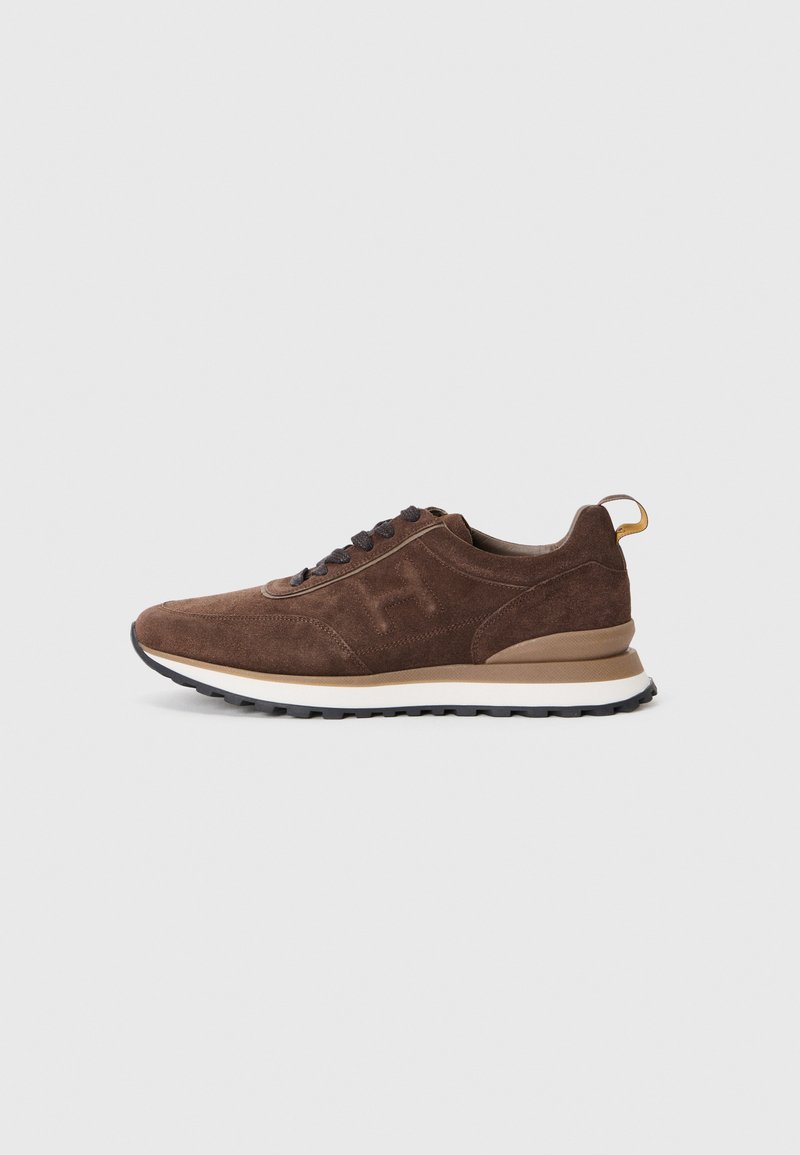 Brown suede sneaker featuring a textured finish, round laces, and a contrasting white midsole with a black rubber outsole.