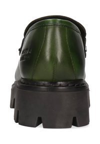 Mocasín de cuero verde oscuro con suela de goma negra gruesa, costuras visibles y marca estampada en el lateral, visto desde atrás.