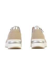 Baskets beige avec semelles blanches et accents argentés au talon, vues de dos sur un fond blanc.