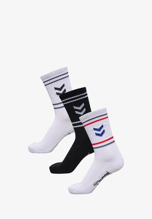 Three pairs of athletic socks: one white with gray stripes and a green chevron, one black with blue stripes and a black chevron, and one white with red stripes and a blue chevron.