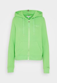 Sudadera verde con cremallera fabricada en un tejido suave. Cuenta con un bolsillo tipo canguro en la parte delantera, capucha con cordón y logo bordado en el pecho.