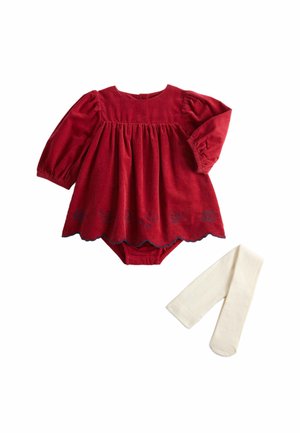Vestito rosso per neonati a maniche lunghe con vita raccolta e orlo ricamato abbinato a collant bianchi su sfondo bianco.
