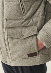 Hall hall talvejope tekstuurse kangaga. Omab suurt klapiga taskut metallkinnitusega ja väikest nahast detaili ääres.