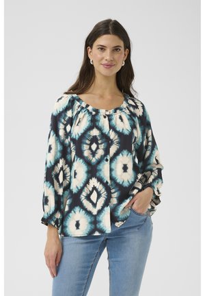 Button-up blouse in dark blue with a tie-dye diamond pattern in cream and teal. Features a gathered neckline and relaxed sleeves.
