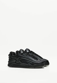 Schwarze Sneaker aus glattem Leder mit strukturierten Oberflächen, ausgestattet mit einer dicken Sohle, einem markanten Schnürsystem und subtilen Designelementen.
