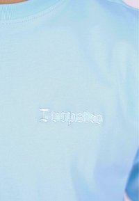 Light blue cotton T-shirt with a round neckline. Features white embroidered text "Dropsize" on the left chest area. Smooth texture.