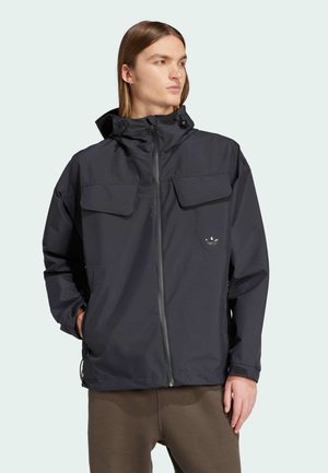 Chaqueta impermeable de color gris oscuro con cierre de cremallera, dos grandes bolsillos en el pecho y capucha ajustable, hecha de tejido ligero.