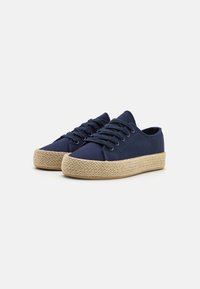 Navy canvas shoes with a woven jute sole, rounded toe, and lace-up design. Features a textured sole for grip.