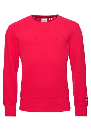 Sweat-shirt rouge vif à col rond, manches longues, poignets et ourlet côtelés, avec un logo "Superdry" discrètement embossé sur la poitrine.