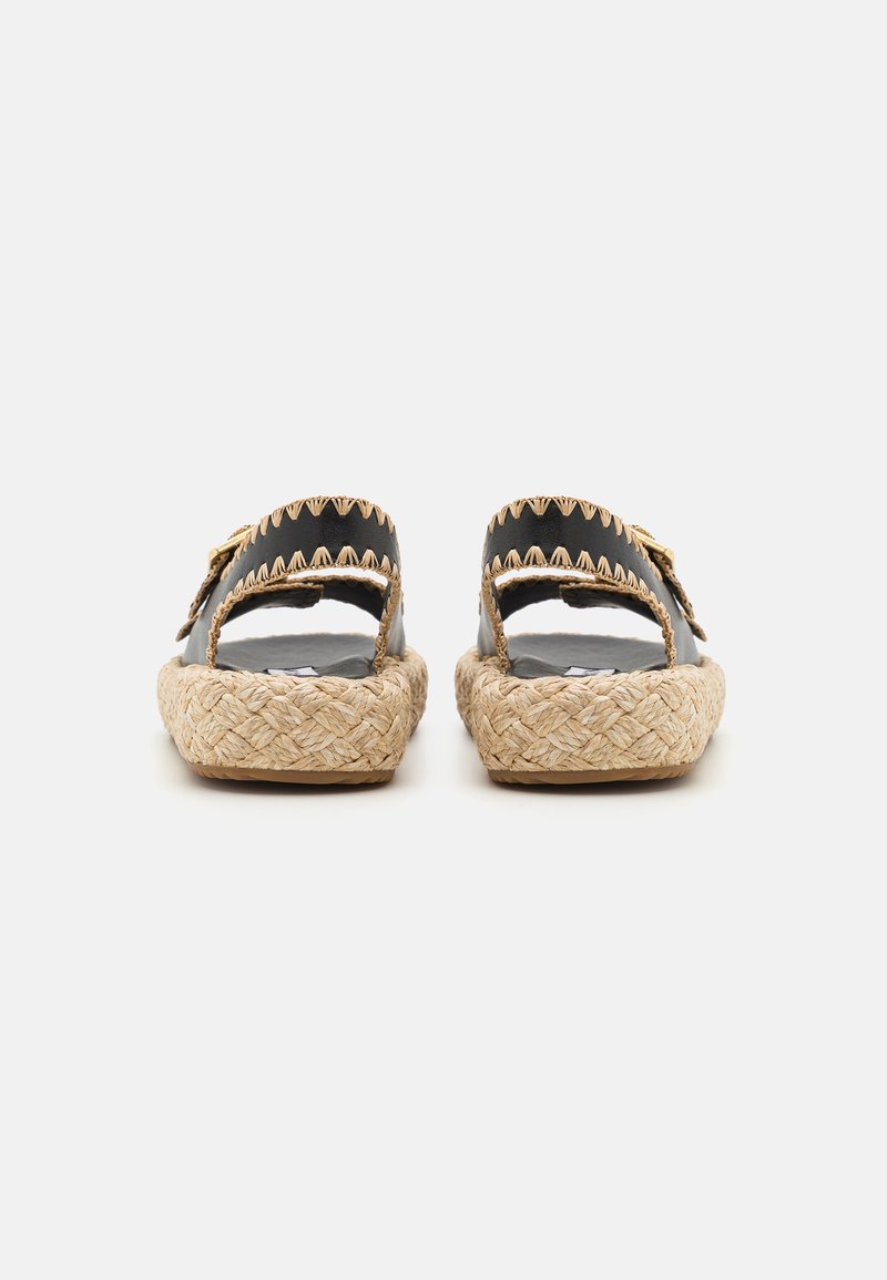 Schwarze Espadrilles mit zwei breiten Riemen, geflochtener Jutesohle und Zickzacknähten an den Riemen. Flaches Design, offene Ferse.