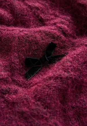 Țesătură texturată, pufoasă, de culoare magenta închisă, cu un accent de fundă din catifea neagră în centru. Aspect moale și cald.