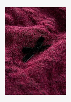 Textured, fuzzy fabric in a deep magenta color, featuring a black velvet bow accent at the center. Soft and warm appearance.