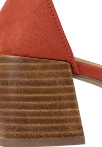 Talon en bois empilé épais avec bride supérieure en daim texturé couleur fauve sur une sandale femme.