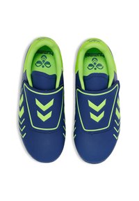 Zapatillas deportivas azules con acentos en verde lima, que cuentan con una textura suave, un diseño sin cordones y un patrón en forma de chevron. Correa elástica en el medio del pie.