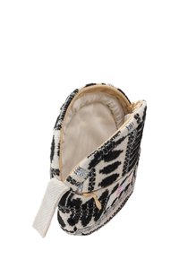 Borsa a sacchetto in tessuto intrecciato bianco e nero con zip, foderata all'interno con una morbida tonalità beige e decorata con una toppa sul fronte.