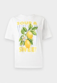 T-shirt bianca in cotone con la scritta grafica gialla "SOUR & SWEET" e un design di due limoni con foglie verdi e un fiore bianco.