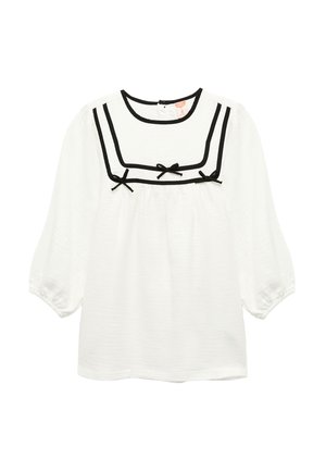 Witte blouse met lange mouwen en zwarte rand rond de vierkante halslijn, met drie kleine zwarte strikjes op de borst.