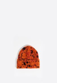 Gorro de lana naranja con manchas negras, con una banda doblada y un acabado suave y texturizado.