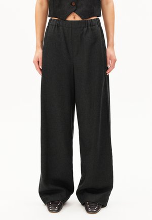 Wide-leg pants in dark gray fabric, featuring an elastic waistband for comfort. Smooth texture with no visible patterns; paired with pointed-toe shoes.