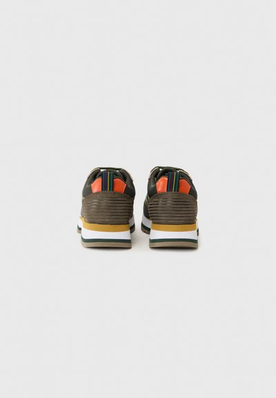 Sneakers din plasă maro cu spate texturat, accente portocalii și detalii multicolore cu dungi. Prezintă o talpă stratificată albă și galbenă.