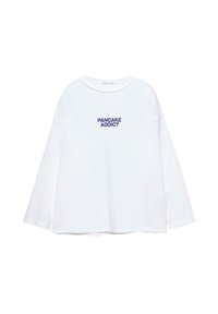Witte longsleeve shirt met ronde hals en donkerblauwe tekst "PANCAKE ADDICT" centraal op de voorkant.