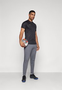 Nike Performance DRI-FIT ACADEMY PANT - Pantalones deportivos - iron grey/dragon red