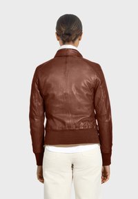 Brun läderjacka med ribbad ärm- och nederkant, figurnära design och slät yta. Har detaljerad sömnad och en klassisk krage.