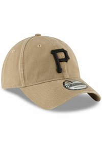 Gorra de béisbol de algodón beige con correa ajustable, logo bordado en negro "P" en la parte frontal y visera curvada. Etiqueta 9TWENTY visible en el lateral.