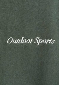 Tessuto verde oliva con una consistenza liscia, caratterizzato da testo ricamato bianco che recita "Sport all'aperto" centrato sul capo.