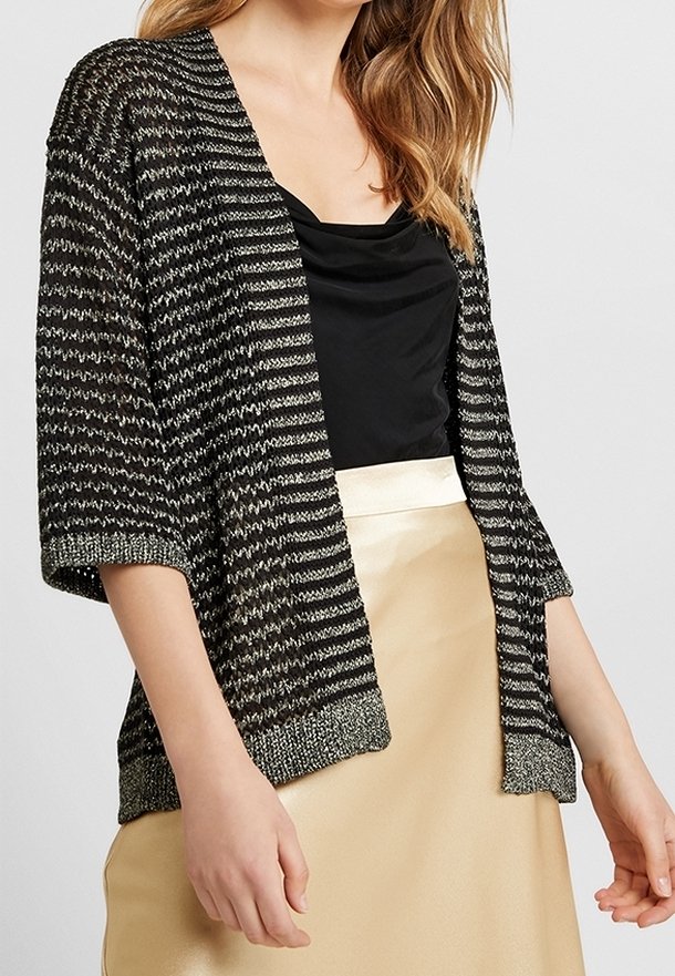 Svart- och vitrandig stickad cardigan med korta ärmar och en texturerad finish, som har en solid svart topp och en satin guldkjol under.