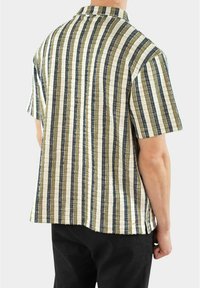 Camicia a maniche corte con colletto, caratterizzata da righe verticali in verde tenue, beige e blu navy, tessuto testurizzato con trama visibile.
