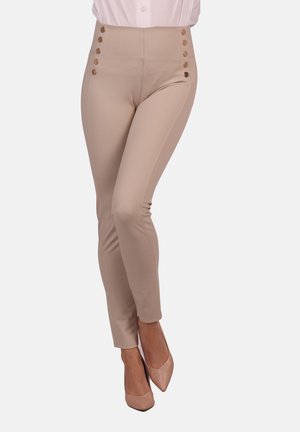 Hochtaillierte, beige Leggings aus dehnbarem Stoff mit goldfarbenen Knopfakzenten entlang der Seitennähte und einer figurbetonten Silhouette.