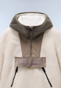 Fleece-pullover i beige og lys krem, med høy krage og glidelås. Har en myk, teksturert overflate og et logo-lapp på brystet.