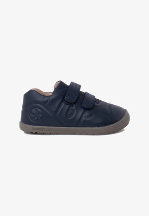 Marineblaue Leder-Kinderschuhe mit zwei Klettverschlüssen, strukturierten Details und einer grauen Gummisohle. Verfügt über geprägte Designs an der Seite.