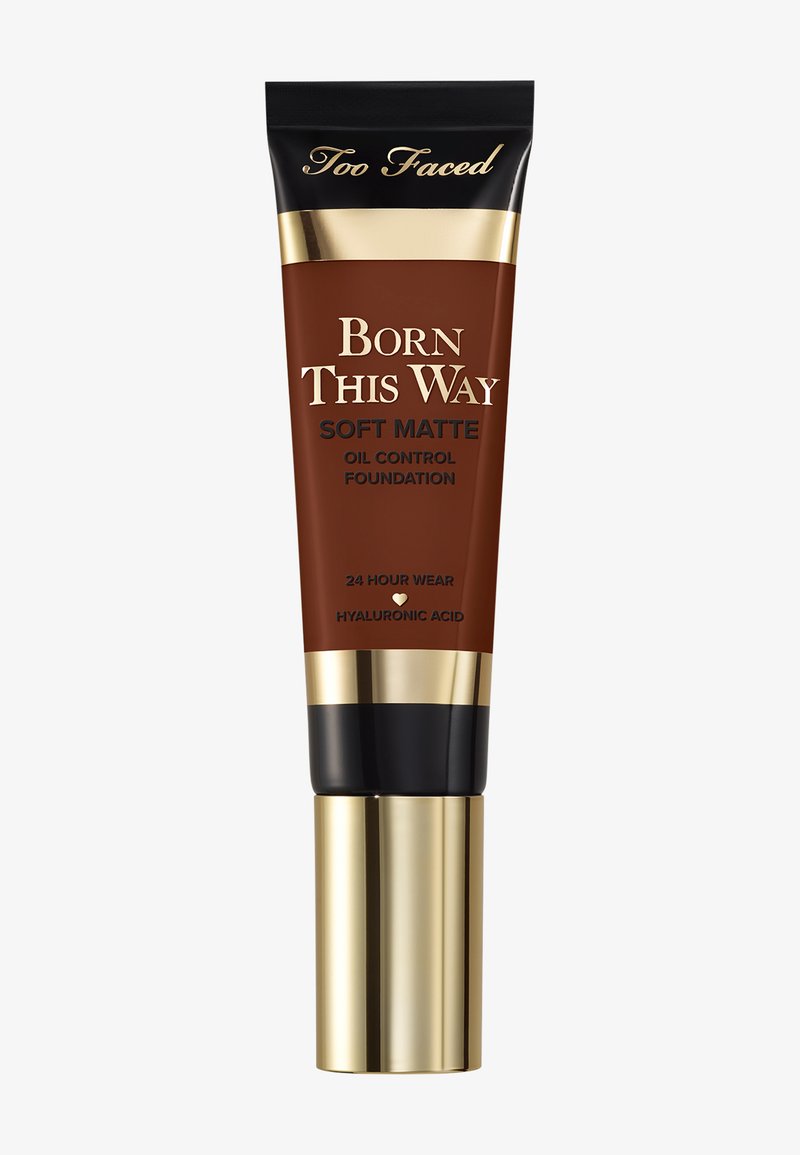 Too Faced Born This Way Soft Matte Oil Control Foundation in a dark brown tube with gold and black accents, featuring a pump dispenser.