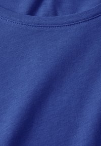 Sininen puuvillakangas, jossa on sileä rakenne ja hieno poikkiveto, jossa on kaareva kaula-aukko ja hienovarainen kiilto materiaalissa.