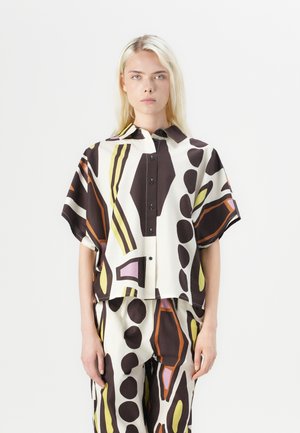 Short-sleeve, collared shirt made of smooth fabric featuring a bold abstract pattern in brown, cream, yellow, and purple accents.