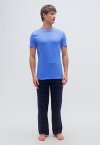 Μπλε κοντομάνικο t-shirt συνδυασμένο με ναυτικό μπλε πυτζάμα παντελόνι με σχέδιο πλέγματος. Βαμβακερό ύφασμα, άνετη εφαρμογή και χωρίς ορατό μεταλλικό εξάρτημα.