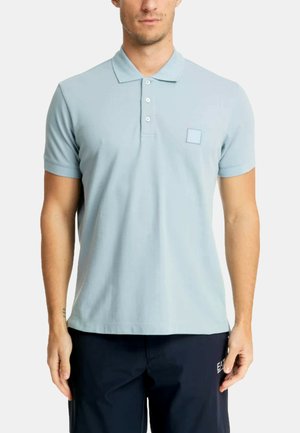 Hellblaues Poloshirt aus strukturierter Stoffqualität mit einer Knopfleiste mit drei Knöpfen. Verfügt über kurze Ärmel und ein quadratisches Logo auf der Brust.