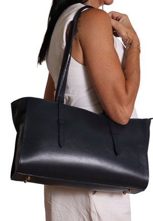 Grande borsa tote in pelle blu navy con superficie texture, due manici robusti e dettagli in metallo dorato nella parte inferiore.