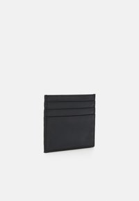 Black leather card holder with four slots for cards, rectangular shape, smooth texture, and minimalist design. No visible hardware or accents.