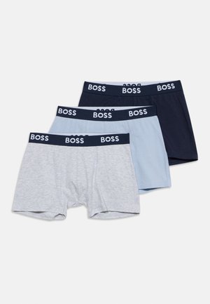 Trois caleçons pour hommes en gris, bleu clair et bleu foncé avec des ceintures noires portant le mot BOSS en lettres blanches.