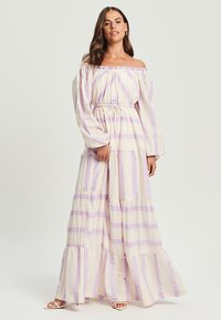 Maxi kleita ar atkailinātām pleciem, ar lavandas un krēmkrāsas horizontālām svītrām, strukturētu audumu un elastīgu jostasvietu. Iespējas kompleksa svārku un garas piedurknes.
