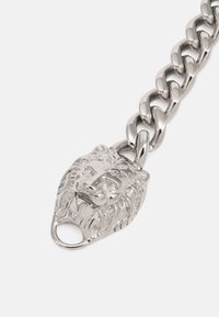 Zilveren kettingarmband met een leeuwenkopsluiting. De schakels zijn gepolijst en afgerond, wat zorgt voor een glanzend, reflecterend oppervlak.