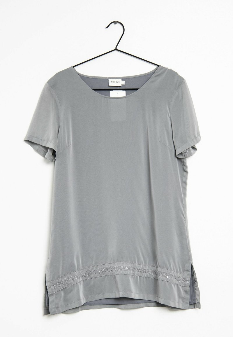 Top gris de manga corta hecho de tejido ligero, con cuello redondo y un dobladillo decorativo con bordados y pequeños acentos.