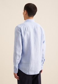 Lichtblauw, langemouw overhemd met knopen, gemaakt van een gestructureerde stof. Heeft een klassieke kraag en knoopmanchetten. Relaxed fit.