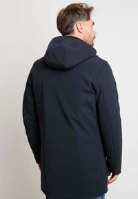 Marineblauwe waterdichte jas met een capuchon, met een gladde textuur en een strakke, moderne uitstraling, gezien van de achterkant.