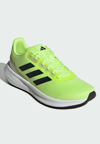 Scarpe da ginnastica verde lime con tre strisce nere e lacci, tomaia in rete, colletto imbottito e suola in gomma bianca testurizzata.