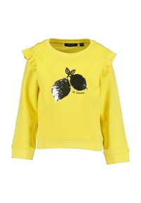 Żółta bluza z falbanami na rękawach, z czarnym i srebrnym cekinowym wzorem cytryny oraz napisem "il Limone" poniżej.